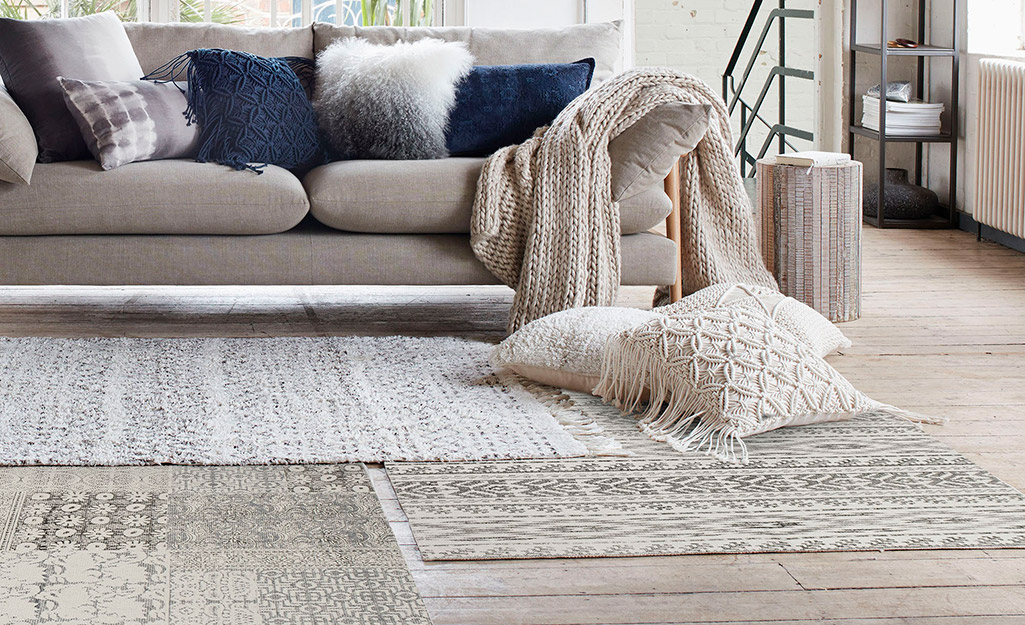 Several layered area rugs in a living room.