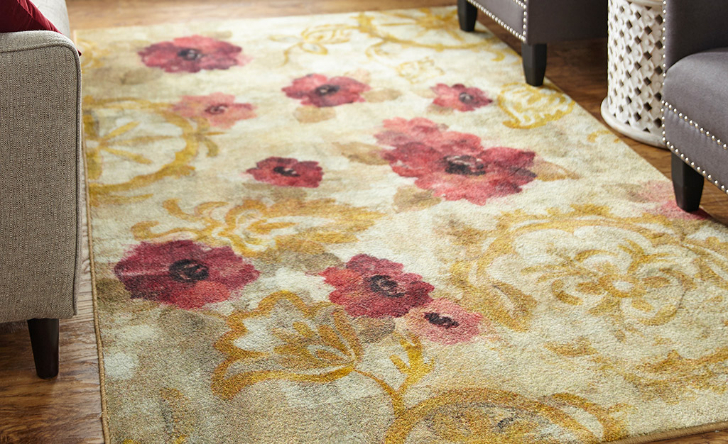 A floral rug with a large pattern of red flowers.