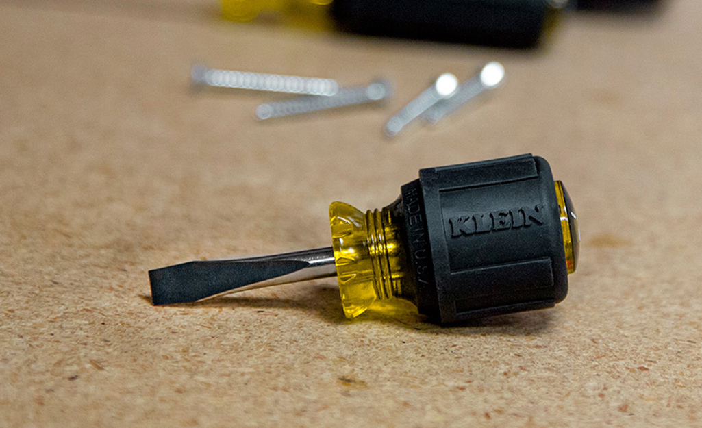 A short-shaft screwdriver with a flat head.
