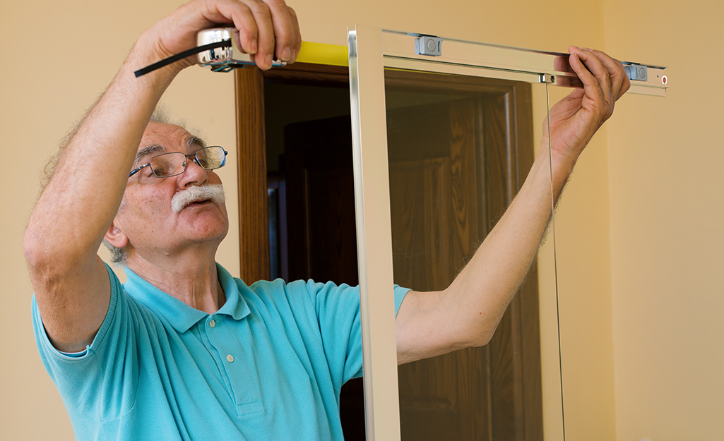 A person measuring shower framing.