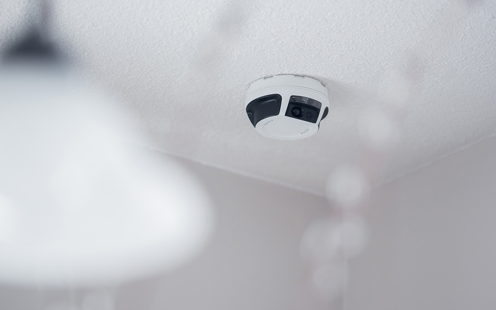 A smoke detector on a ceiling.