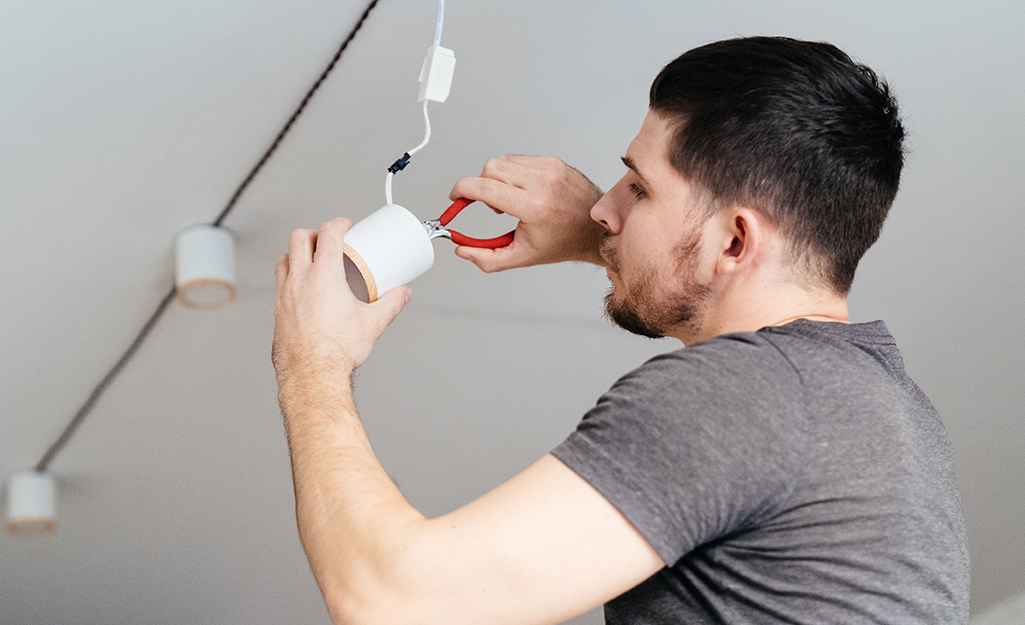 Someone wires track lighting in a home.