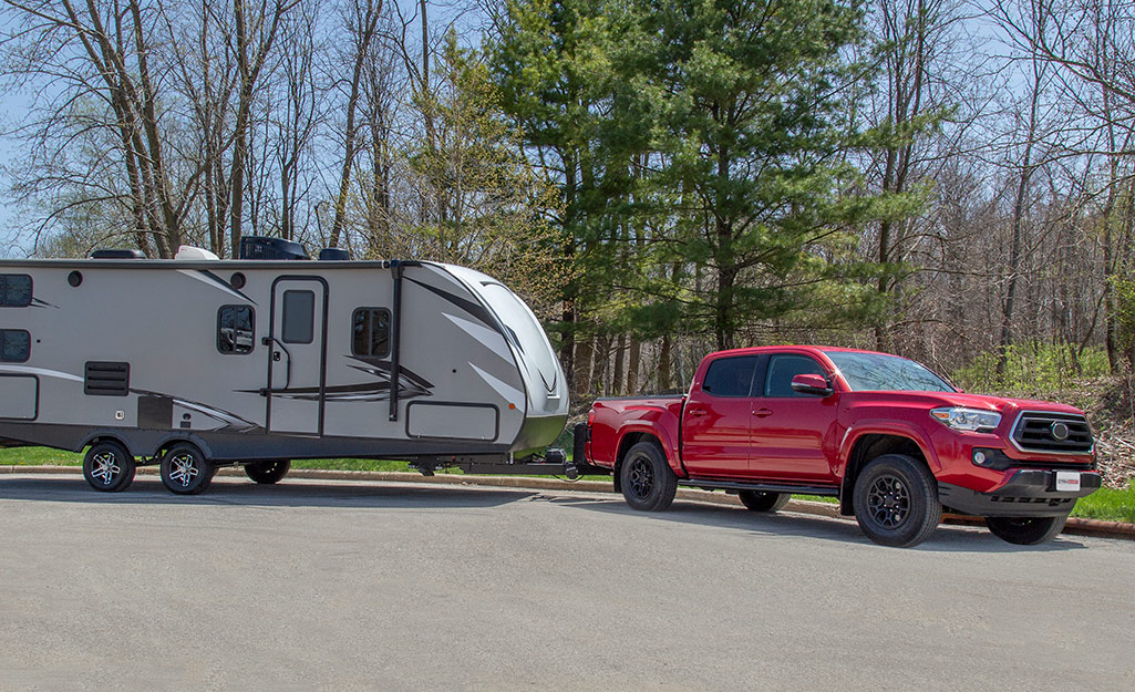 A red pickup truck pulls a travel trailer.