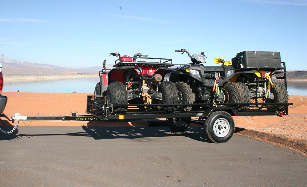 A utility trailer hauling four-wheelers.