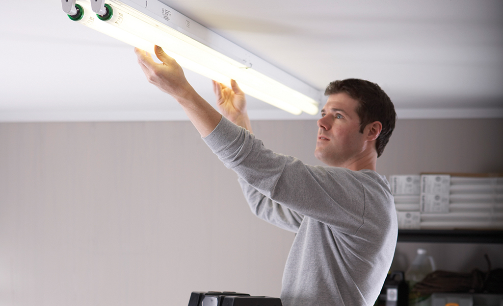 A person installs a tube light.