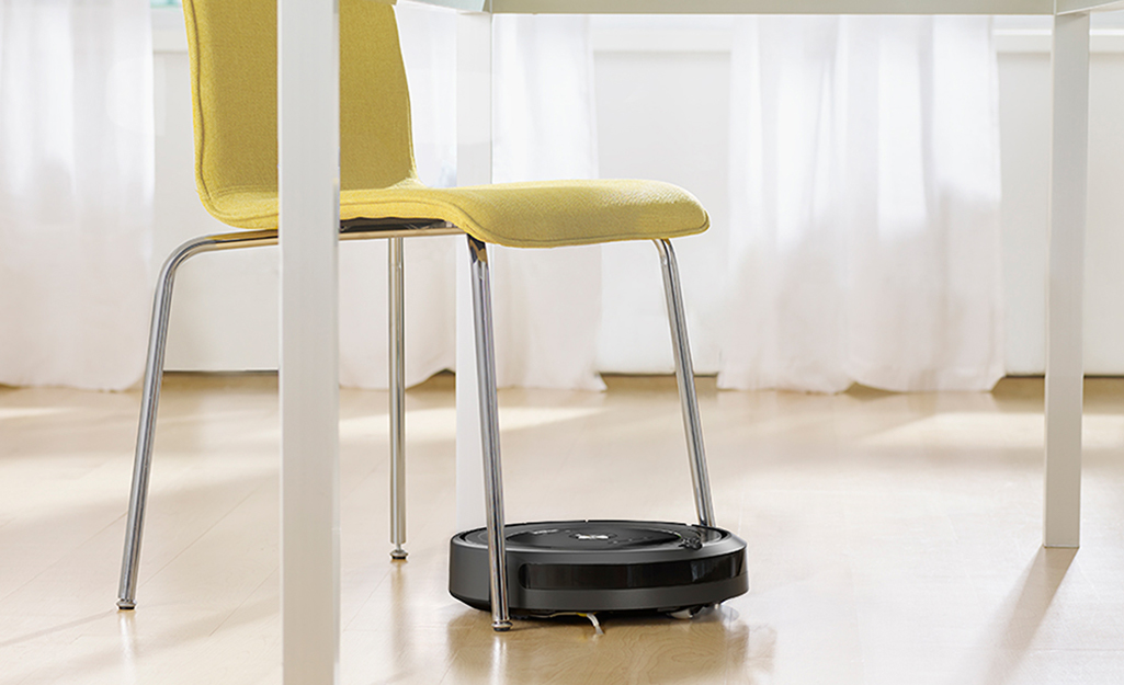 A robotic vacuum atop hardwood floors.