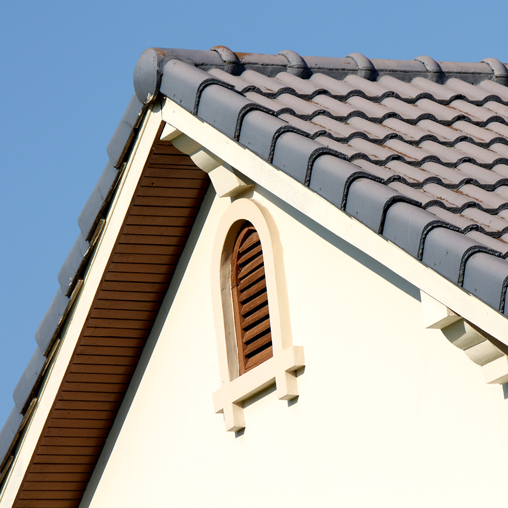 A close up on the roof of a home featuring an attic vent.