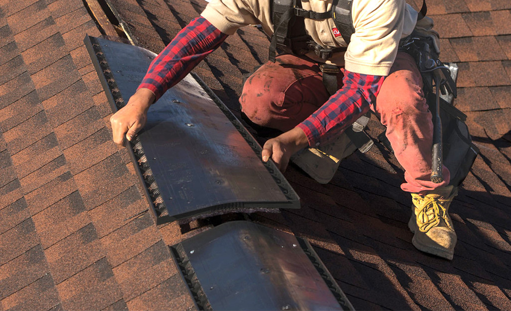 A man installing roof vents on a roof.