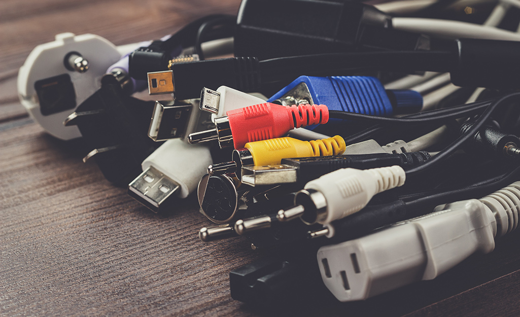 Different types of cables lying on a wood table.