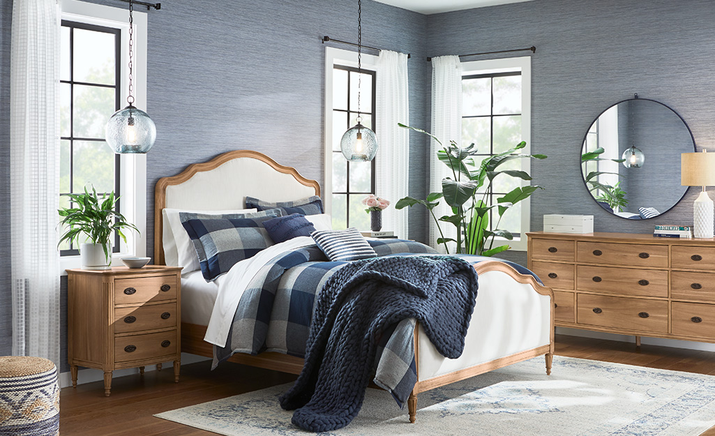 A bedroom with grayish blue wallpaper.