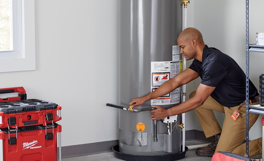 A person installing a tank water heater.