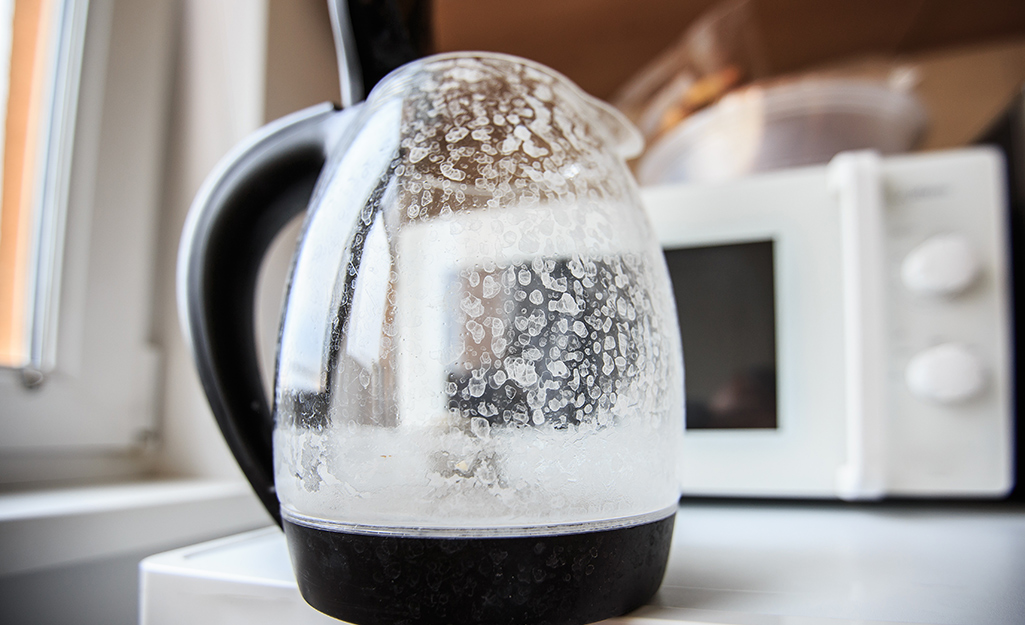 A glass coffee pot with hard water stains.