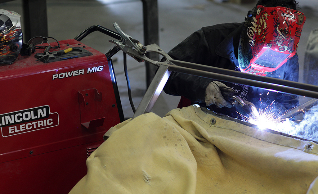 A man is using a MIG welder.