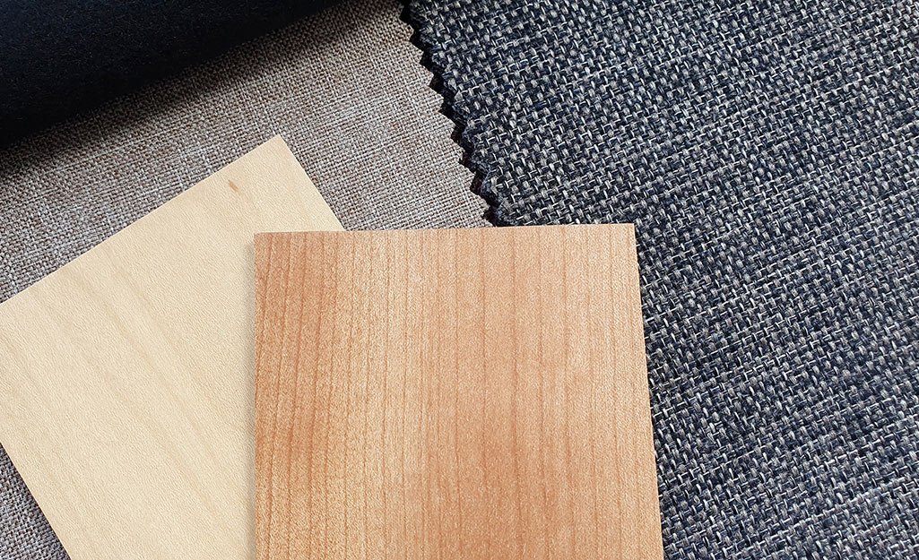 Wood, fabric and plastic window treatments spread out on a table.