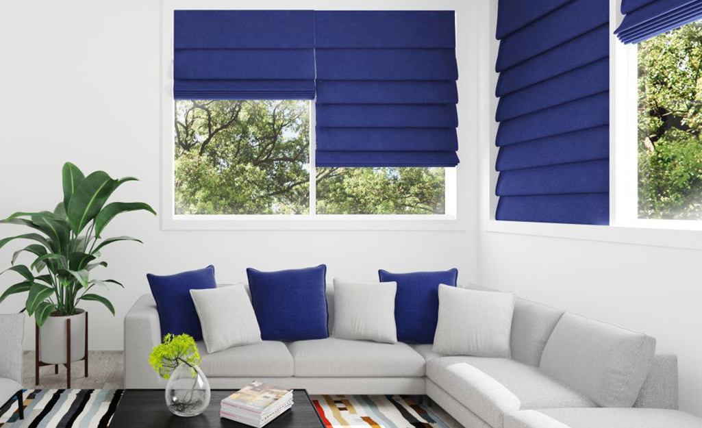 Blue Roman shades hanging in sunroom windows.