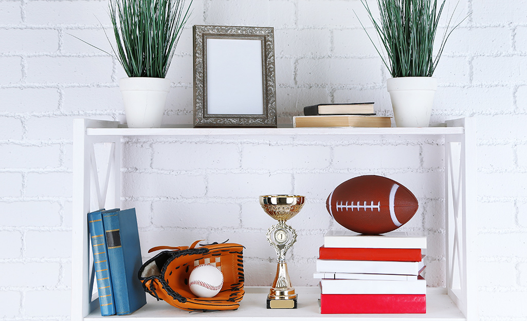 Sports memorabilia on display shelves in a home. Sports memorabilia on display shelves in a home.