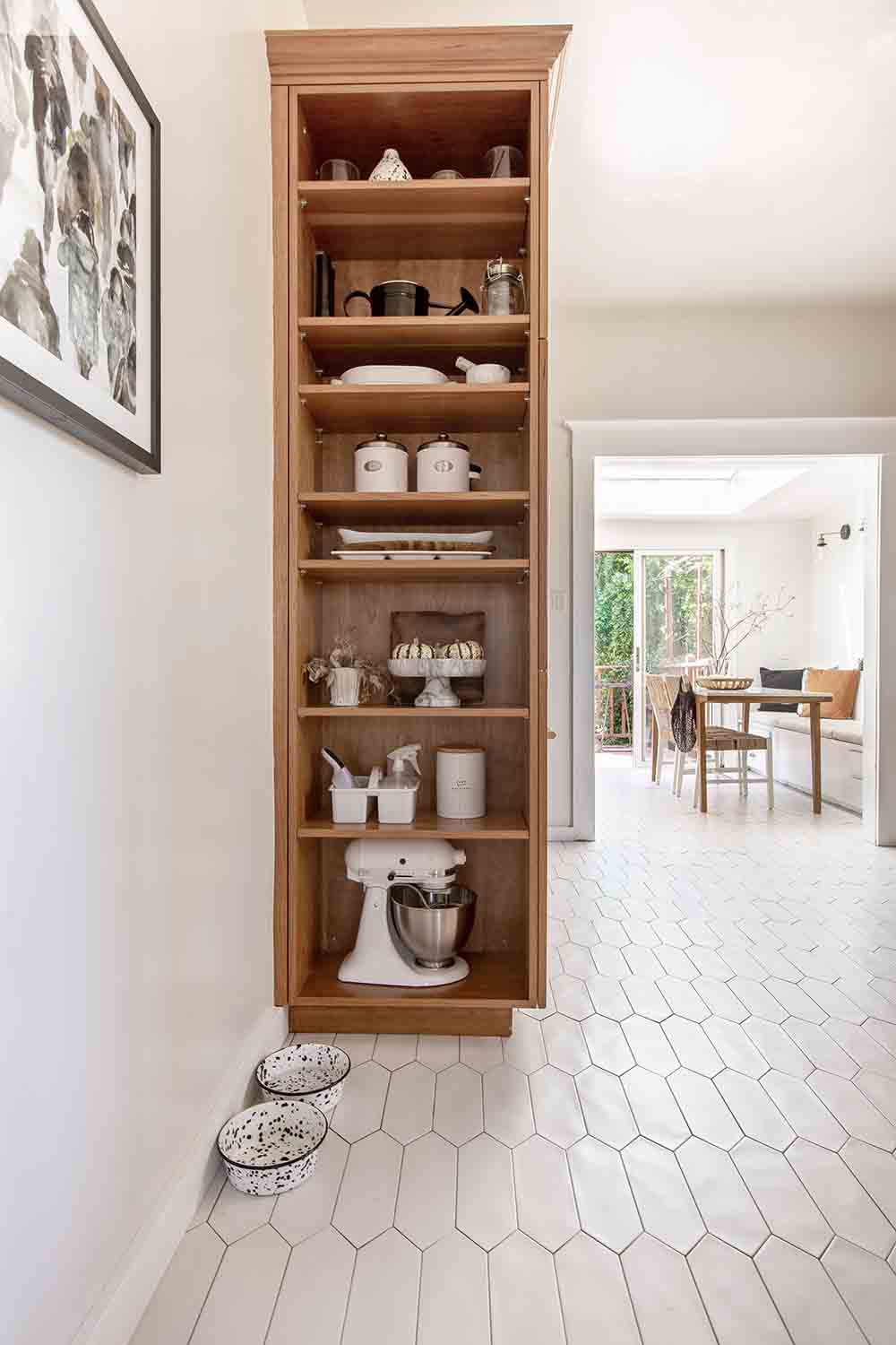 A tall cabinet with shelving for kitchen storage.