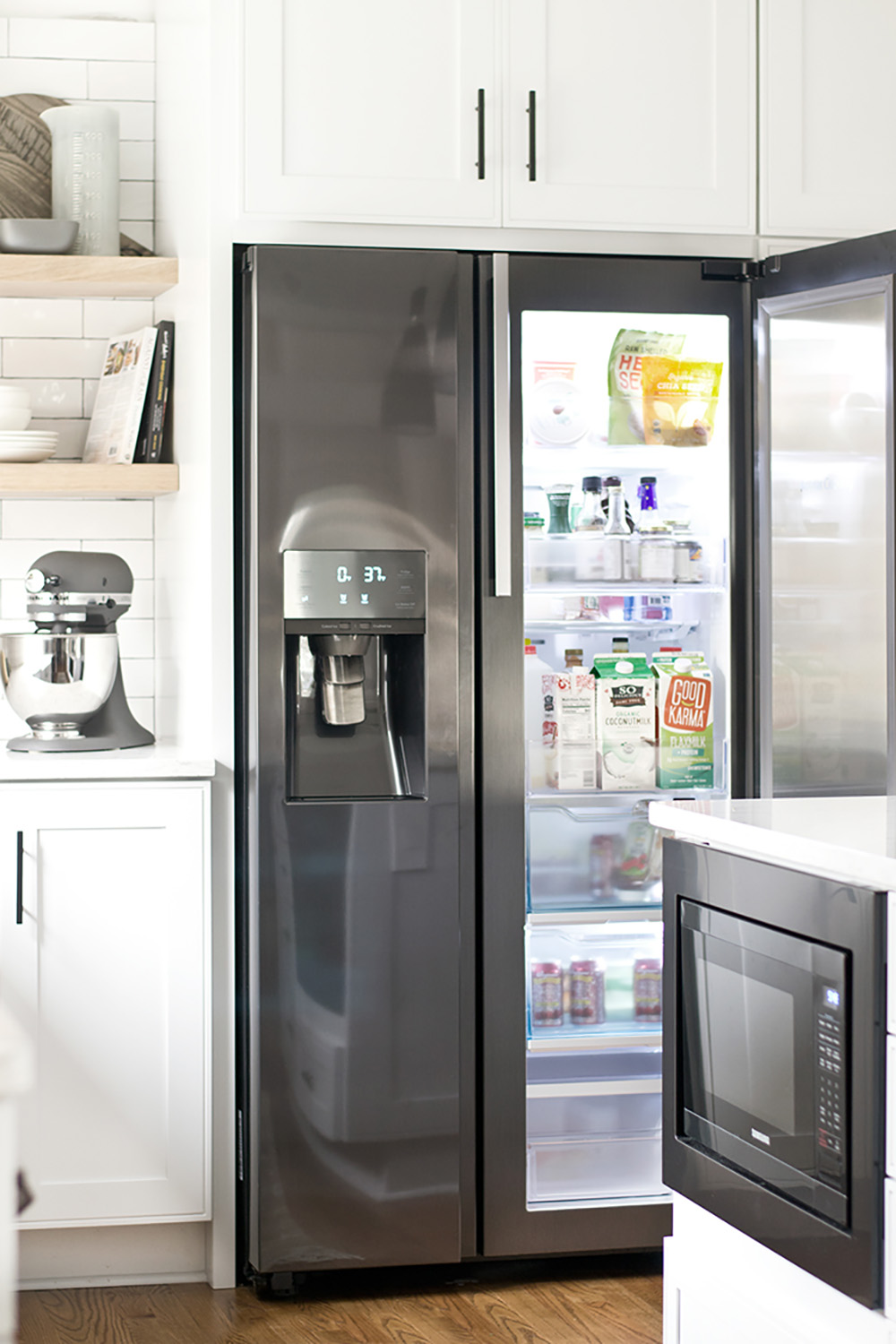 The corner of a kitchen with a black stainless steel Samsung refrigerator.