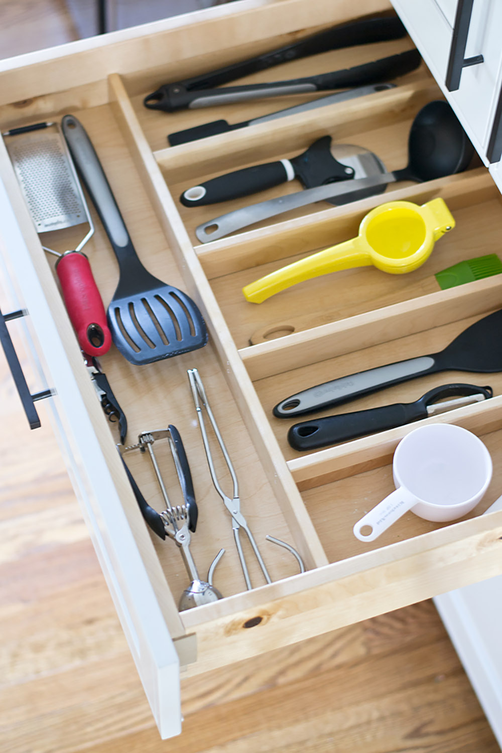 An open kitchen drawer with wooden dividers.