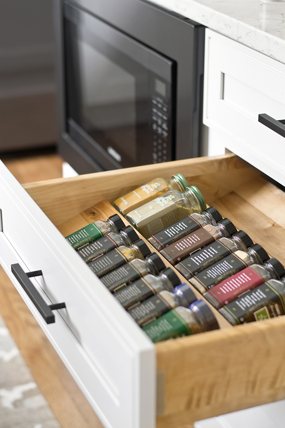 An open kitchen drawer with spice drawer insert.