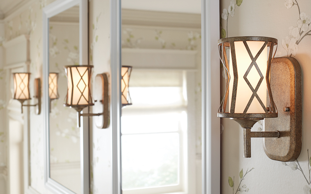 Elaborate sconce lighting over a white furniture style vanity.