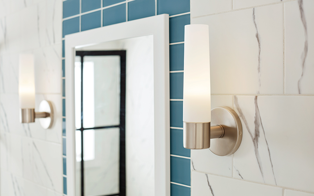 Warm white vanity lights with a modern geometric design in a modern decor bathroom.