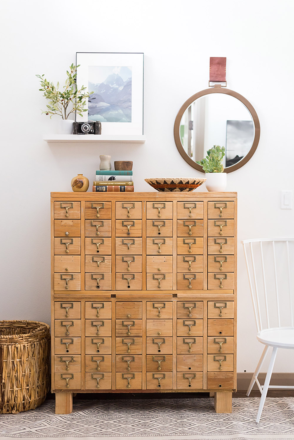 A wooden card catalog with books and various decor items on top. A wooden card catalog with books and various decor items on top.