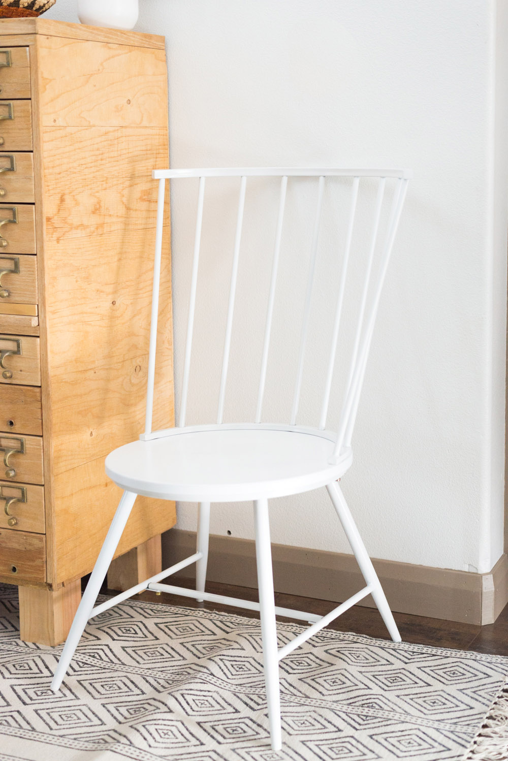 A white Windsor-style chair sitting on a rug. A white Windsor-style chair sitting on a rug.