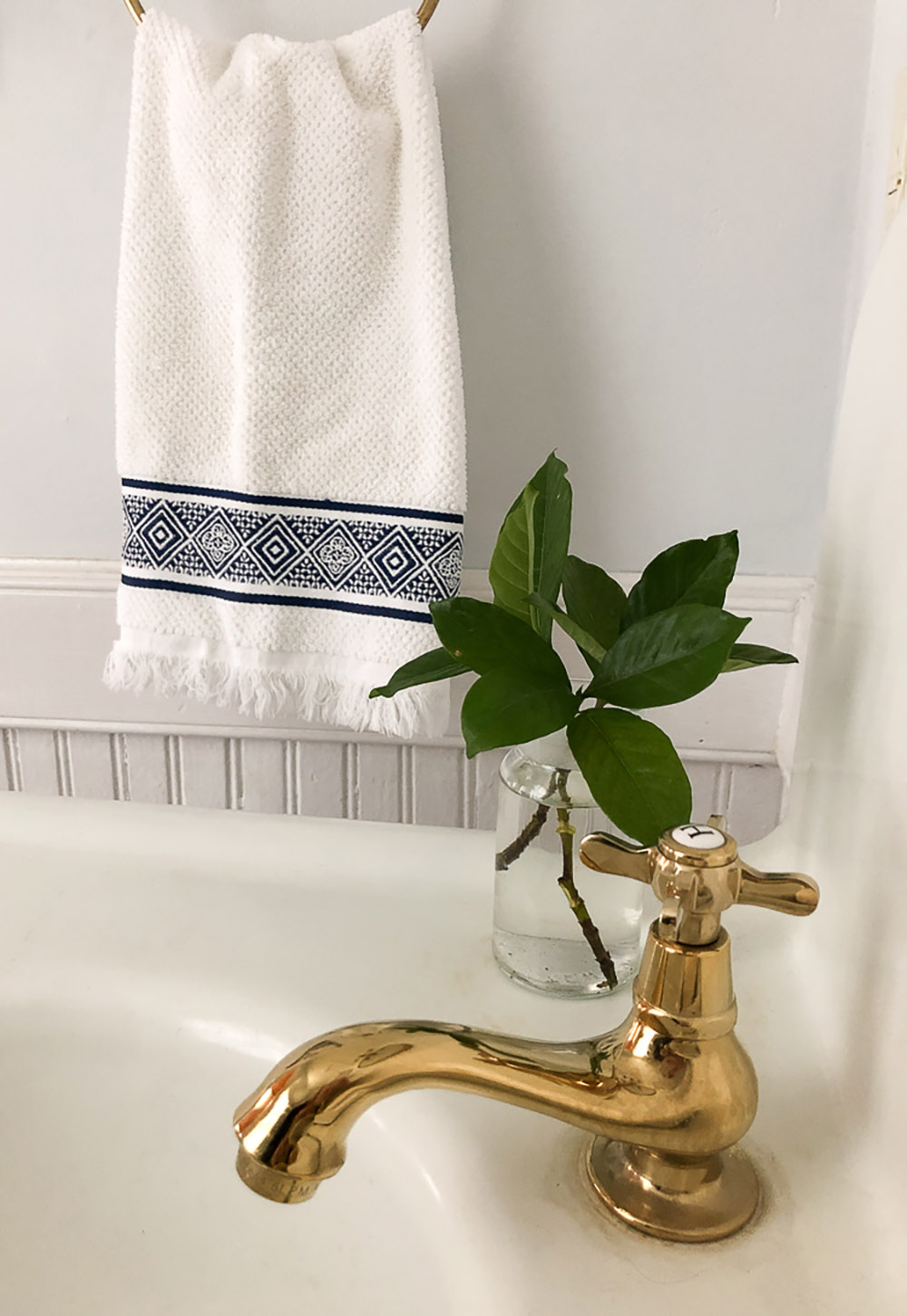 A brass hot fixture on a white cast-iron apron front sink.