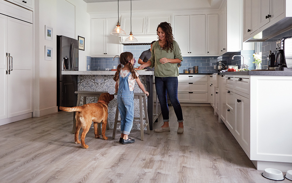 A mom, child and the family dog enjoying a durable, beautiful vinyl floor in the kitchen.