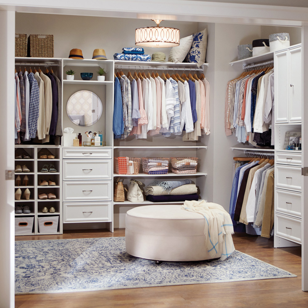 Shirts hang from rods in a large walk-in closet that also includes shelves and drawers for storage. Shirts hang from rods in a large walk-in closet that also includes shelves and drawers for storage.