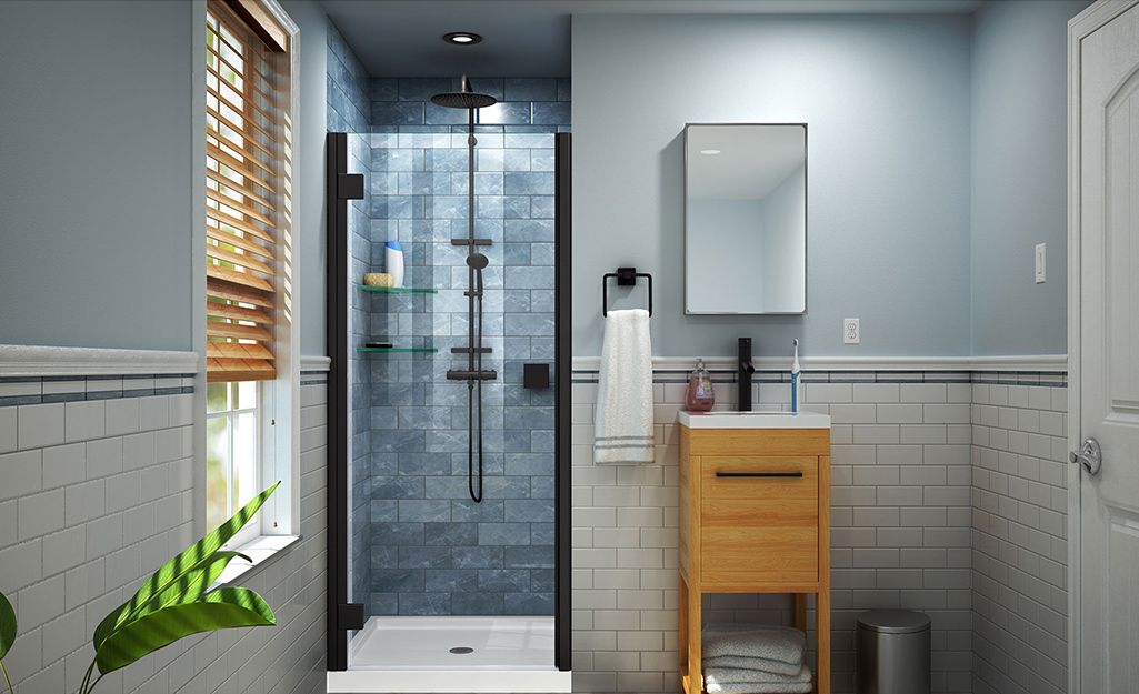 A bathroom with  a walk-in shower with tiled walls, glass doors and a rainfall type shower head.