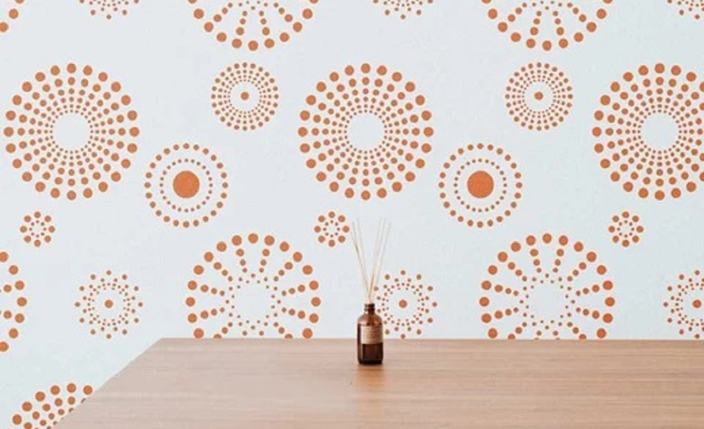 A stencil of orange dots in different sizes used as wall art.