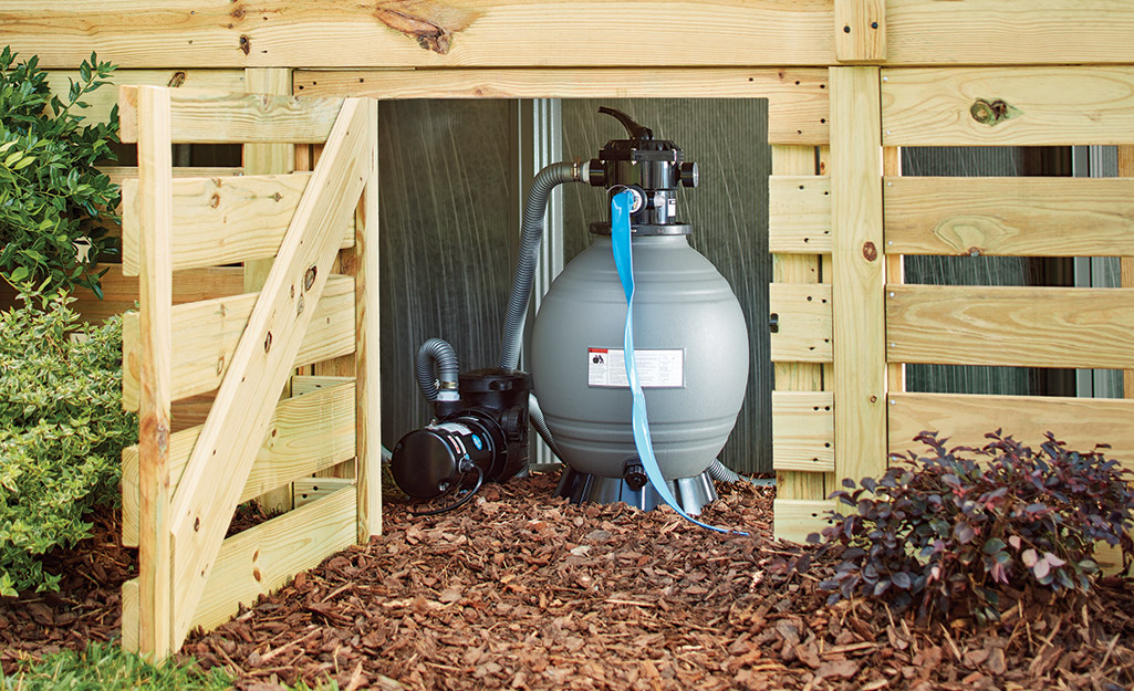 Pool pump inside a wood outdoor shed.