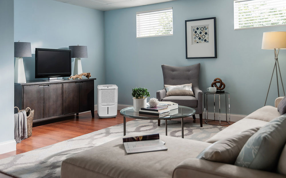 A 70-pint dehumidifier sits in the corner of a living room.