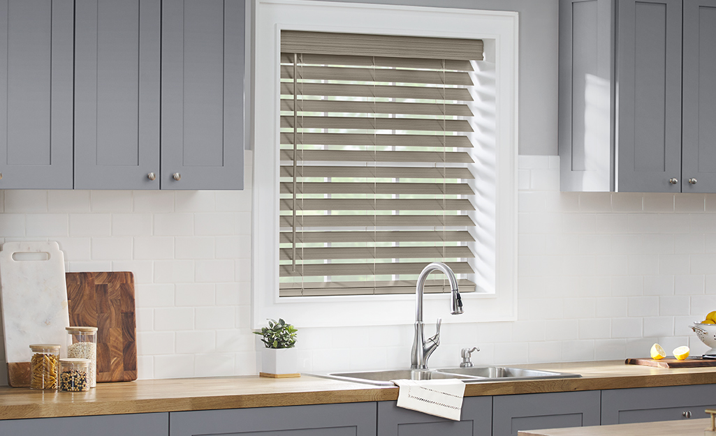 A kitchen window with blinds.
