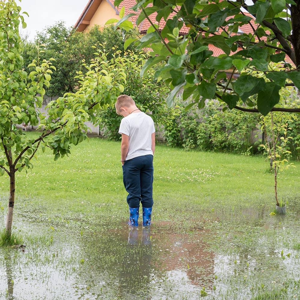 Boy standing in a flooded yard