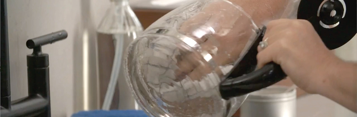 Person cleaning glass coffee carafe. Person cleaning glass coffee carafe.