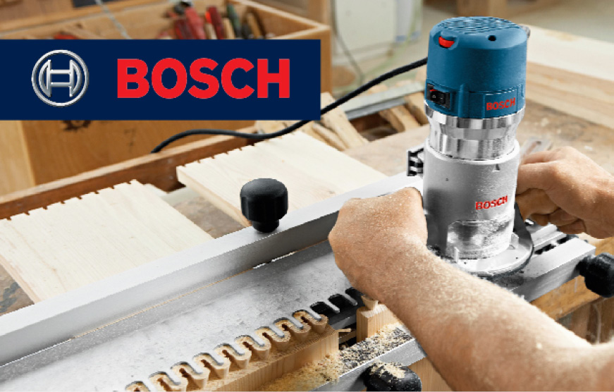 Hands holding Bosch router in use. Hands holding Bosch router in use.