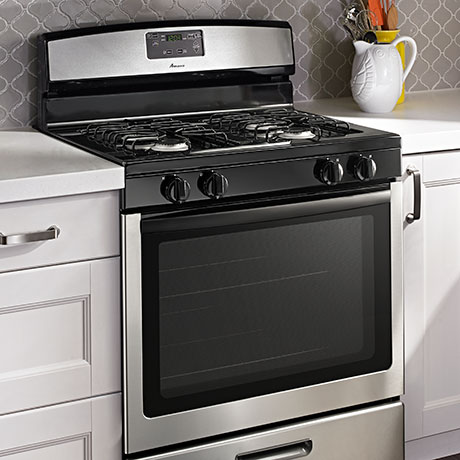 An angled view of the stainless steel range shows the raised edge around the perimeter of the cooktop.