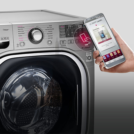 Close up of a hand holding a smartphone with the Smart Diagnosis App open in front of an LG washing machine