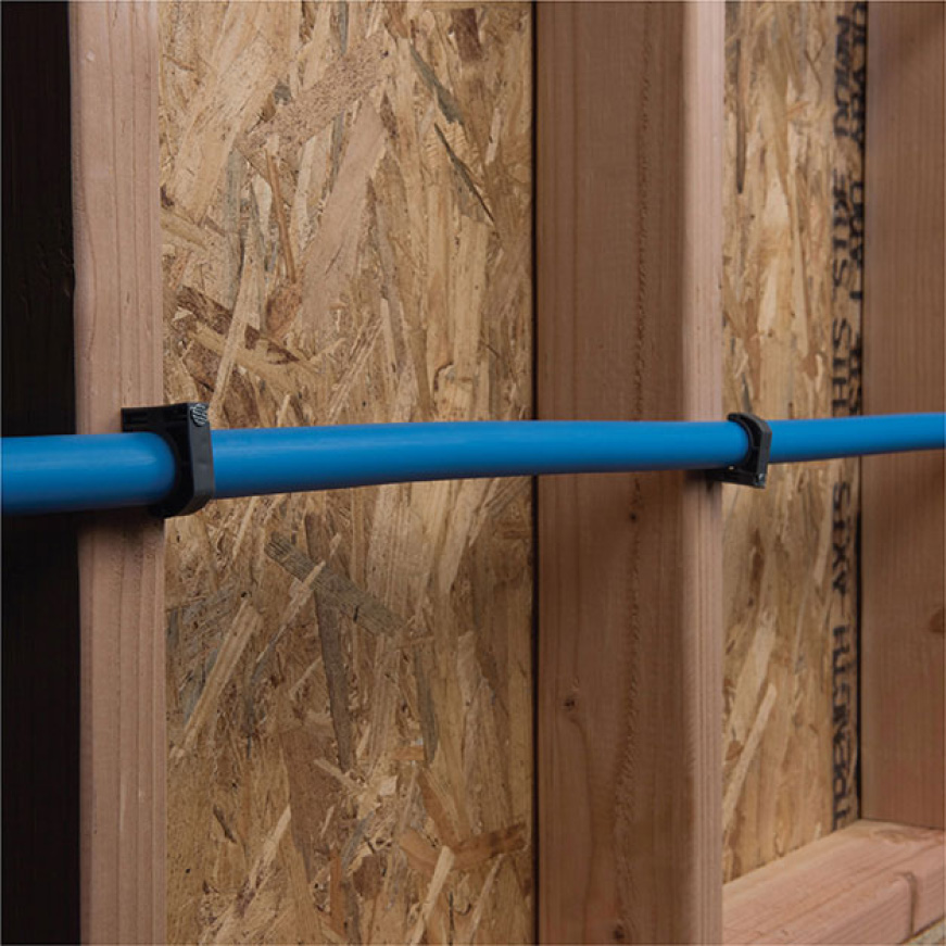Piping secured to wall with clamps Piping secured to wall with clamps