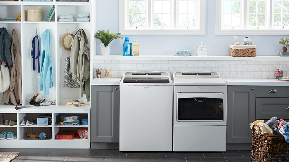 White washer and dryer pair set in a modern laundry room. White washer and dryer pair set in a modern laundry room.