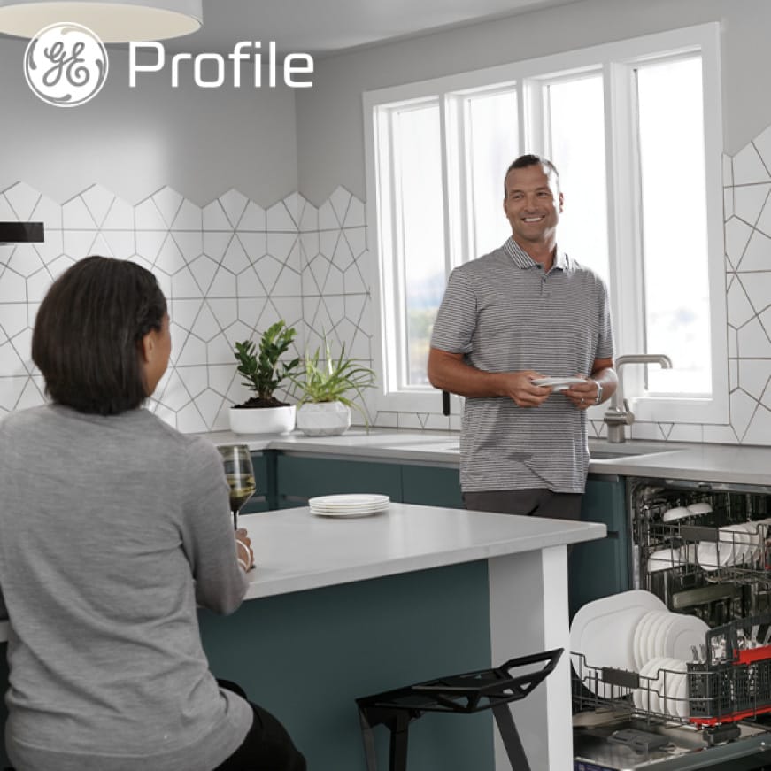 A couple laughs as they talk in a modern kitchen. A couple laughs as they talk in a modern kitchen.
