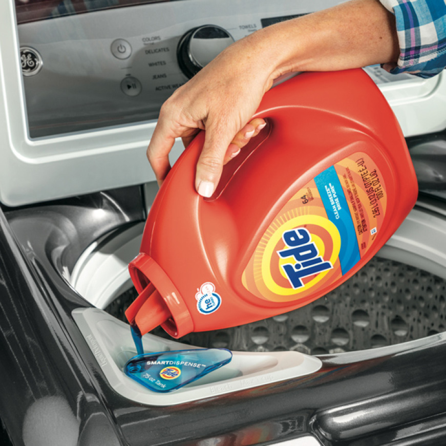 Hand pouring a bottle of Tide detergent into the SmartDispense detergent tank Hand pouring a bottle of Tide detergent into the SmartDispense detergent tank