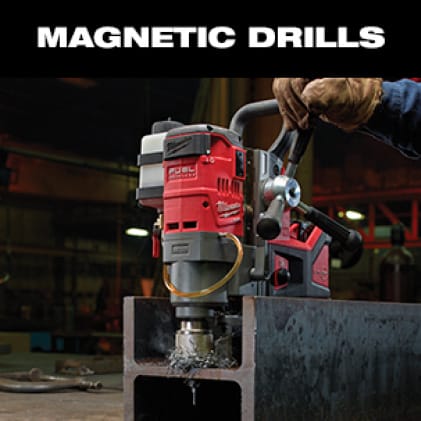 A man wearing work gloves uses the M18 FUEL Magnetic Drill to cut a hole in steel beam.