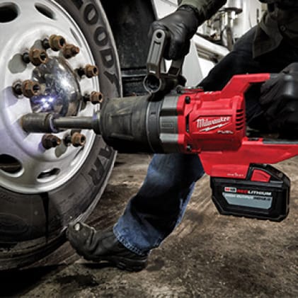 Professional using M18 FUEL D-Handle High Torque Impact Wrench to fasten car lug nut.