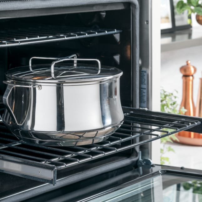 An image of a kitchen with sleek Cafe appliances is superimposed over a woman dressed in trendy clothes that match the kitchen. An image of a kitchen with sleek Cafe appliances is superimposed over a woman dressed in trendy clothes that match the kitchen.