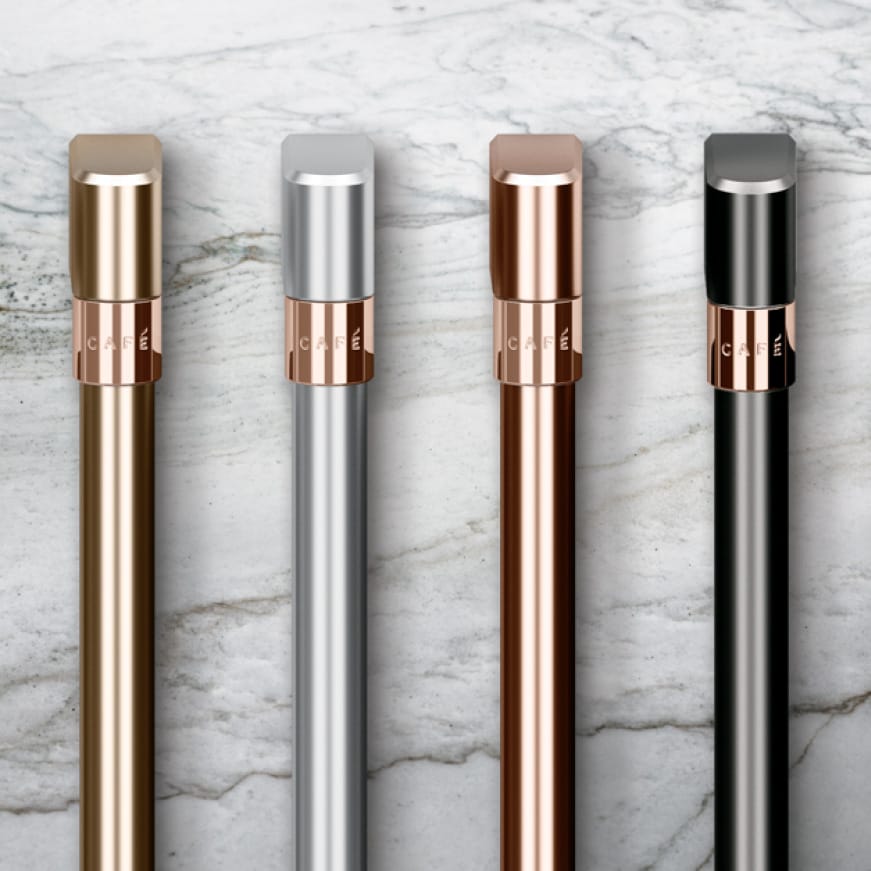 Brushed steel, brushed bronze, brushed black, and brushed stainless finish handles rest side-by-side on a marble counter.