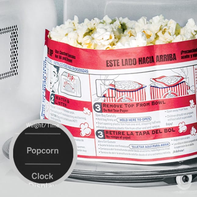 Popcorn cools off in the microwave.A circular overlay shows the popcorn button on the control panel.